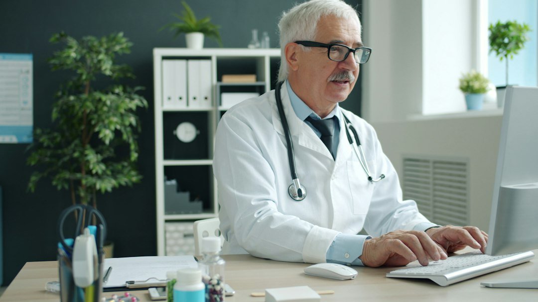 Healthcare specialist working at a computer in a clinic